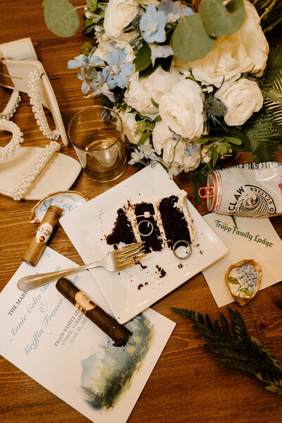 A tablescape of wedding momentos, from a bride's white heels to the bouquet, rings and slice of cake.