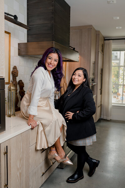 Two female real estate agents pose together in kitchen for The Garcia Collective.