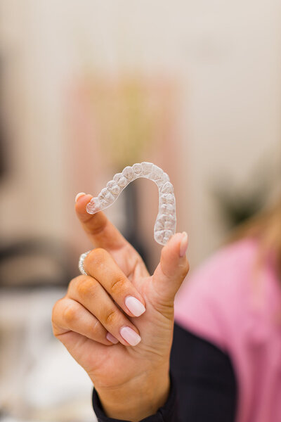 Orthodontic specialist holding up clear aligners at Stewart Orthodontic Studio in Jonesboro AR