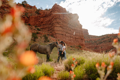 Couple with horse in front of red rocks