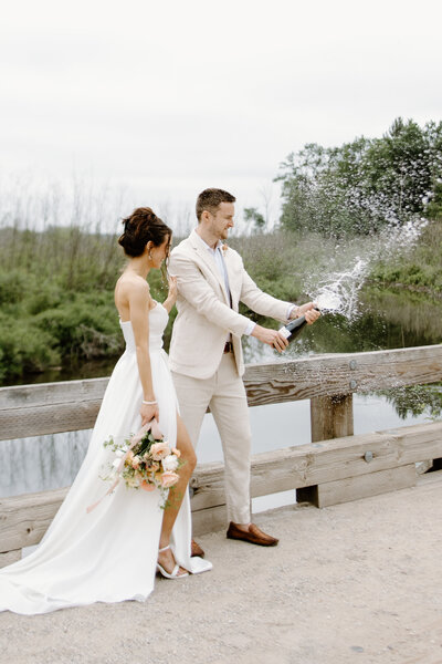 Bride and groom popping champagne.
