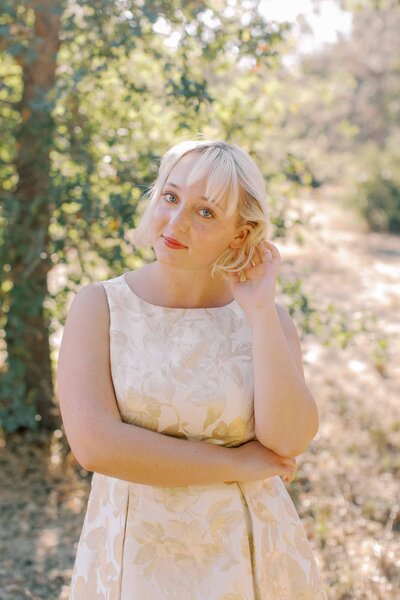 Blonde high school senior tucking her hair behind her ear