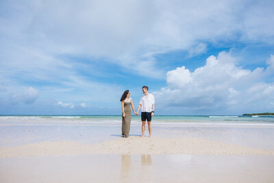 engaged couple walking on beach