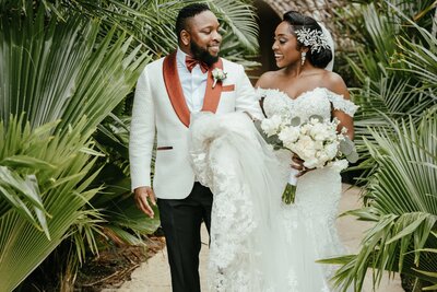 Nigerian couple smiles at each other among tropical plants