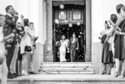 Bride and groom walking out of ceremony to bubbles