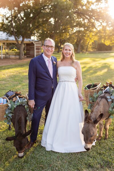 Bride and groom pose with beverage-serving donkeys during their sunset Hill Country wedding, planned with personality and fun details.