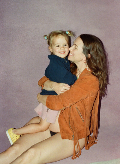 Mother lifting baby up in her arms at in home photography session in Austin