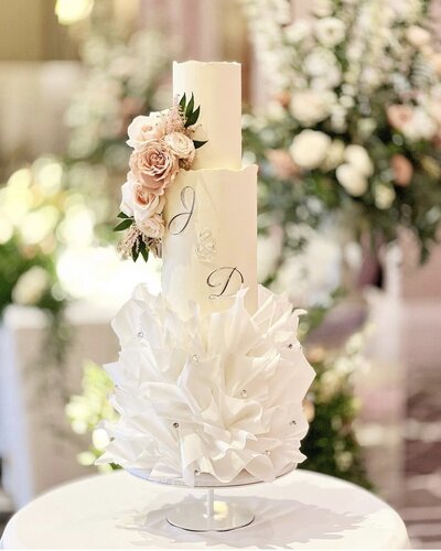 Three tier Asian Wedding Cake at Syon Park Conservatory with a floral cake meadow of bring spring flowers & gold initials