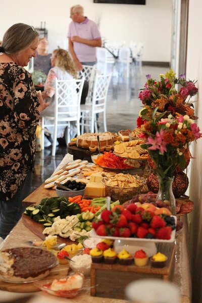 Hand holding two plates of catered food at event