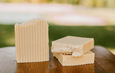 honeysuckle scented bars of goat milk soap displayed on a table