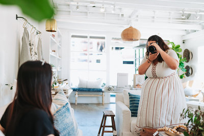 woman photographing client on sofa