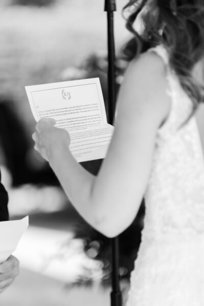 A bride reads her wedding vows in a black and white photo
