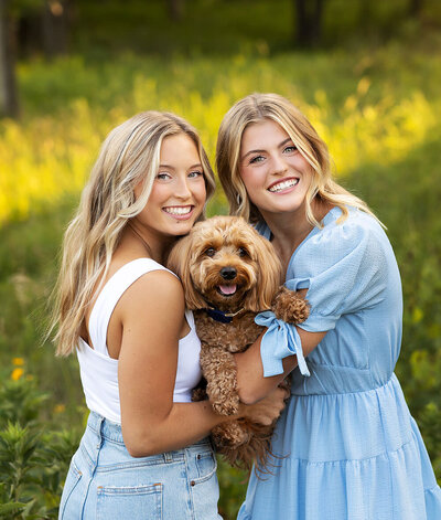 Two Sisters holding their dog during their MN Family Photo session Adam Hommerding Photography