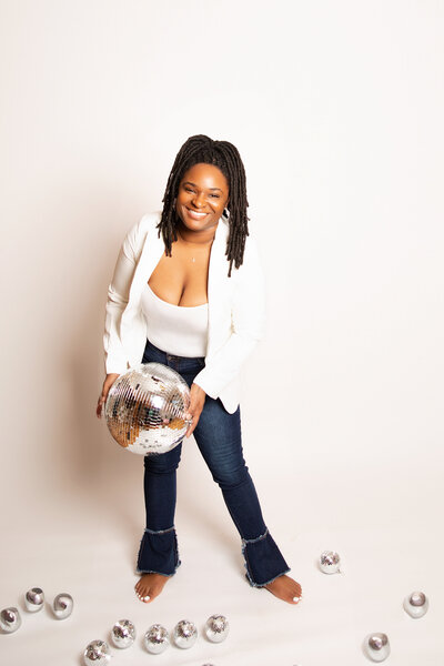 Kristal smiling with disco ball in hand at Hacker Medias Chattanooga Photography Studio.