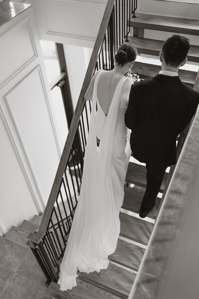 A couple walking up the stairs at Arlington Estate on their wedding day.