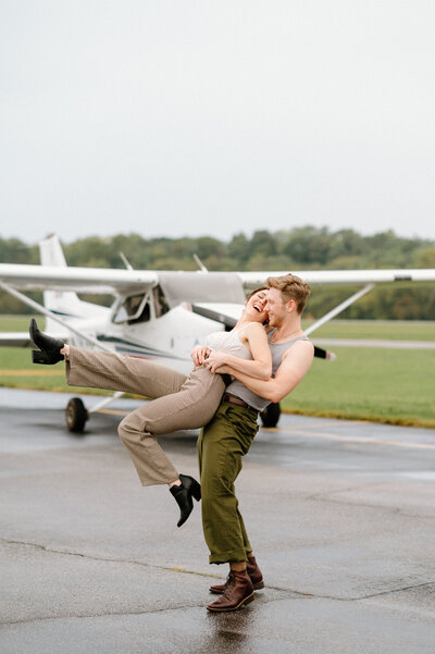 Engagement photos in front of a small private airplane in vintage outfits in Colorado