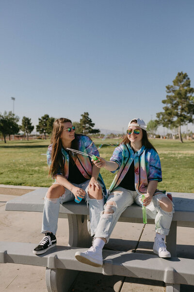 KP and Jessie blowing bubbles in a park