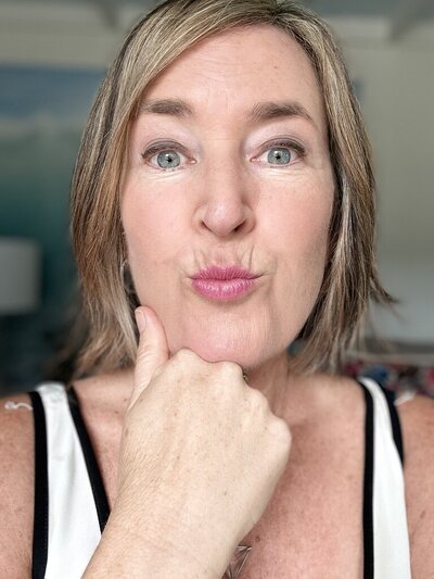 Close-up of Laura Kate McHugh with a playful, sassy expression, showing confidence, humor, and authenticity in the healing journey
