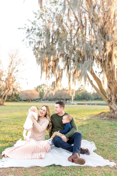 family sitting on a picnic blanket