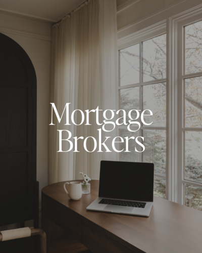 Close-up of a woman in a light blue shirt working on a laptop while holding a cup of coffee, representing focus and productivity, ideal for showcasing streamlined business systems and efficient workflows