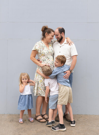 family having fun together in front of a blue wall in Downtown McKinney