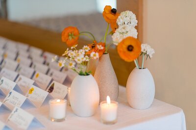 Cards lined up with a few orange and white floral accents.