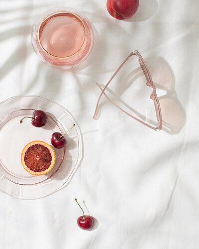 Plate of fruit and glasses on a white surface