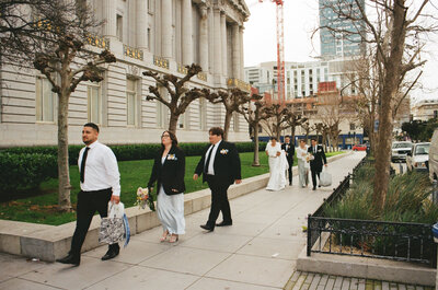 wedding party walking outside of city hall