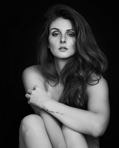 Black and white boudior photo of woman with long dark hair