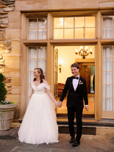 November wedding at Graylyn Estate, designed and planned by Charming Carolina — bride and groom being introduced into cocktail hour, smiling as guests cheer.