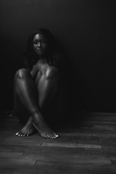 Young woman sitting on floor, knees bent, legs crossed