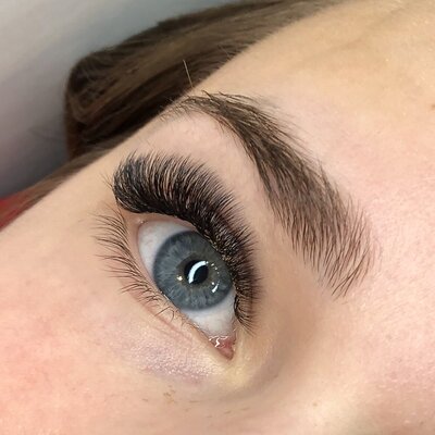 Blue eyes with a classic volume eyelash extension set, performed by industry veteran and educator, Kristen Maxwell