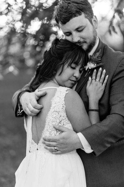 Bride resting head on grooms shoulders at Finger Lakes wedding, New York