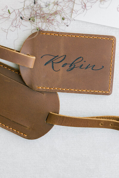 Personalized debossed leather luggage tag with calligraphy.