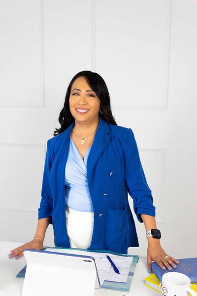 Professional bilingual career coach offering her incredible services in the office, dressed in a blue and yellow outfit, ready to help clients achieve career growth and confidence.
