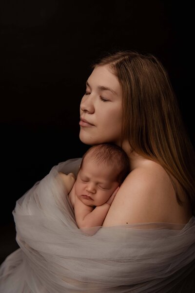 Expecting mom seated on the floor in a feminine red dress, showcasing her stylish and relaxed vibe. Captured by a Mobile, AL maternity photographer, the image highlights her hipster style with a soft, elegant touch.