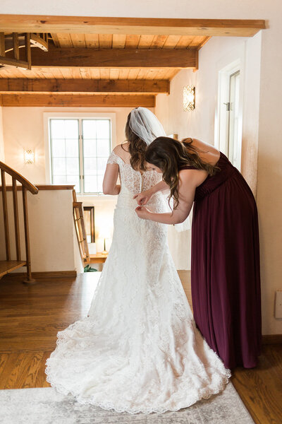 Chateau Lill Woodinville Wedding Venue - Photo Bride in getting ready room putting her wedding dress on