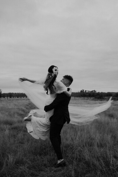 black and white photo of groom spinning bride at cadella park wedding