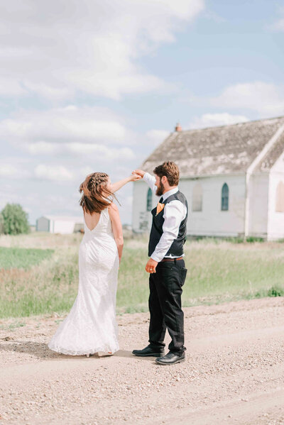 Bride holding husband's arm on a walking path at the U of S.