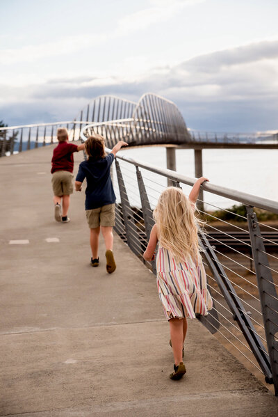 Kids running on bridge at Chambers Bay park family photos