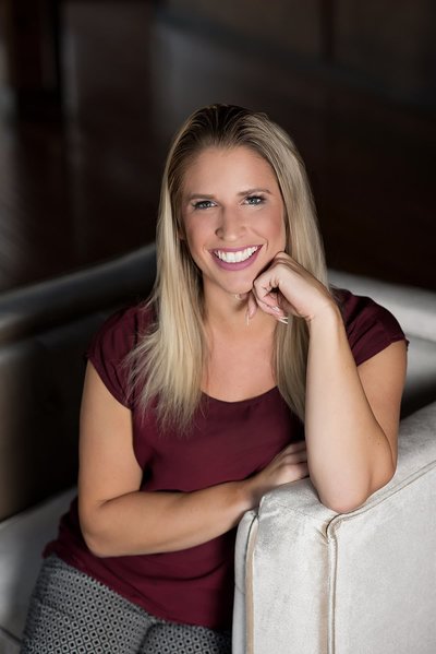 Headshot of wedding planner wearing maroon and smiling at the camera