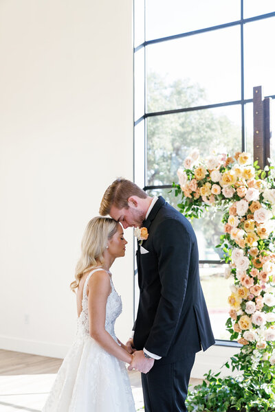 Groom kisses bride on forehead