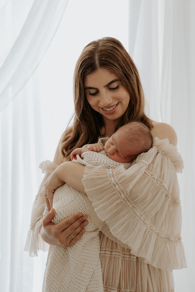 mother cradling newborn baby at indoor photography session in perth