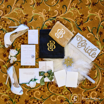 Chic wedding flat lay featuring gold, black, and white details for an elegant celebration.