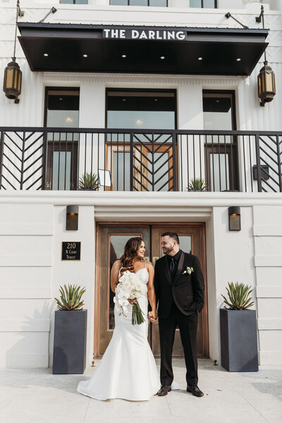 bride and groom posing outside of venue