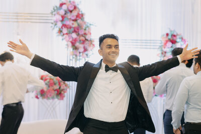the willows at ashcombe wedding venue is an art deco mansion between philadelphia and harrisburg. a groom on the dance floor lifts his arms up during the reception hour. image by philadelphia wedding photographer emily wilkerson