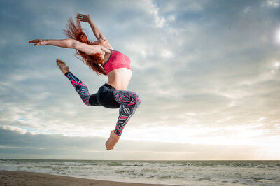 Woman jumping in the air on the beach