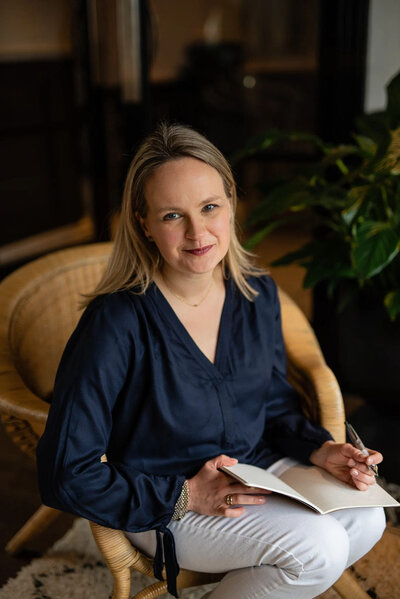 women sitting on a chair with her notebook and pen in hands