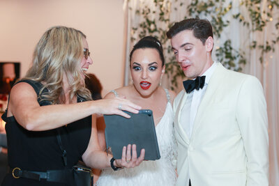 wedding photographer showing slideshow to bride and groom