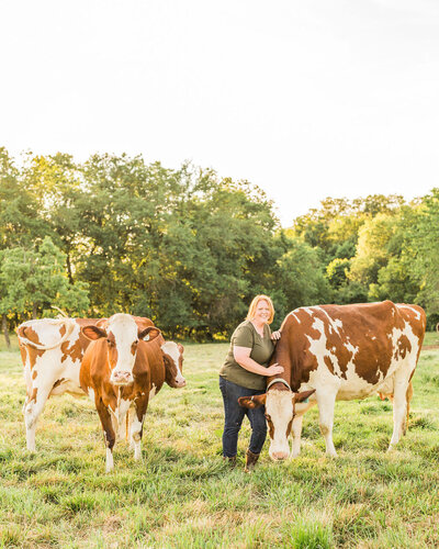 woman standing next to cows